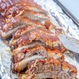 cut slab of Instant Pot BBQ pork ribs on a foil-lined baking sheet
