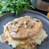 Instant Pot Pork Chops with Mushroom Gravy on a serving plate over mashed potatoes