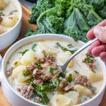 eating pressure cooker tuscany soup with a spoon from a white bowl