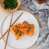 Air Fryer Sweet Chili Salmon on a white plate with chopsticks on the side