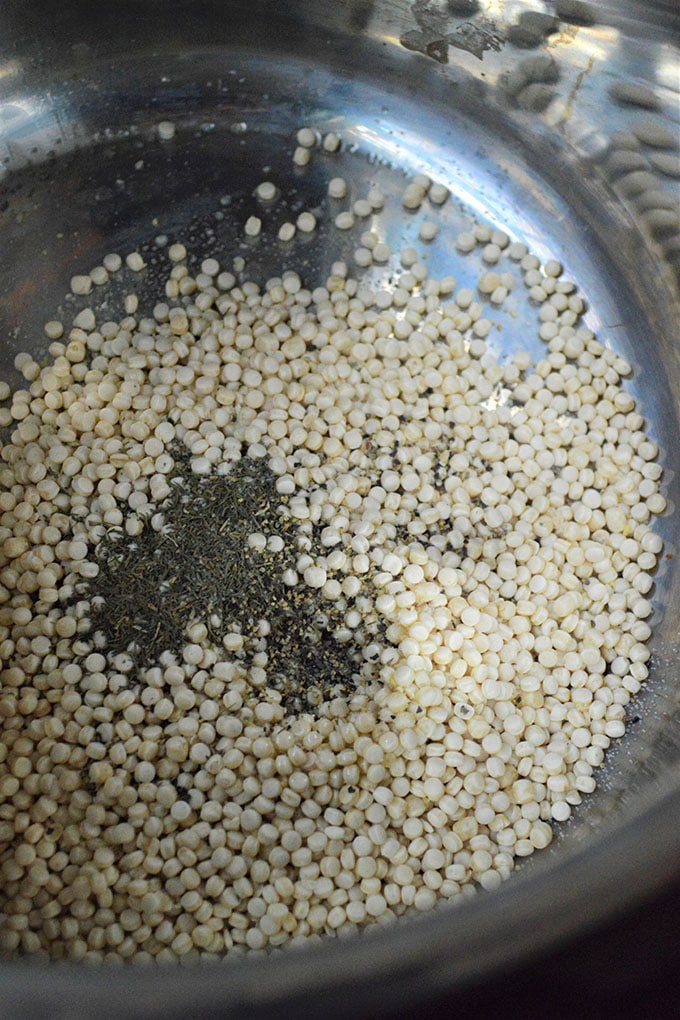uncooked pearl couscous with dried dill in the Instant Pot