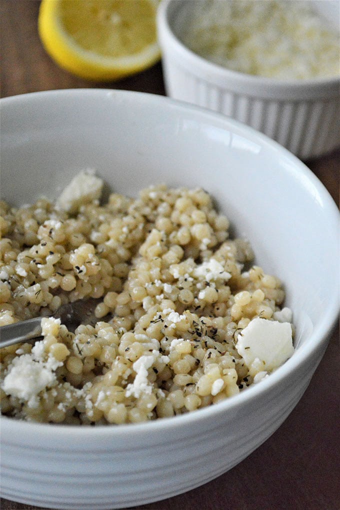 pressure cooker pearl couscous in a white bowl with feta cheese