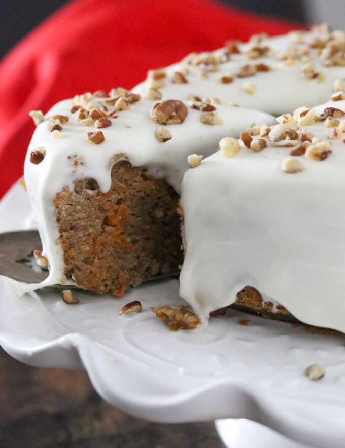 serving slice of pressure cooker carrot cake on a cake stand