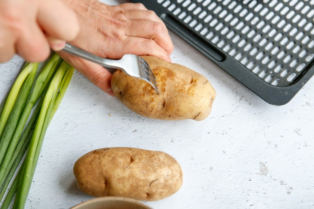 poking Russet potatoes with a fork