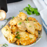 garlic parmesan chicken thighs in a white serving bowl